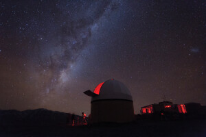 View of milky way with observatory in foreground at top of Mt John