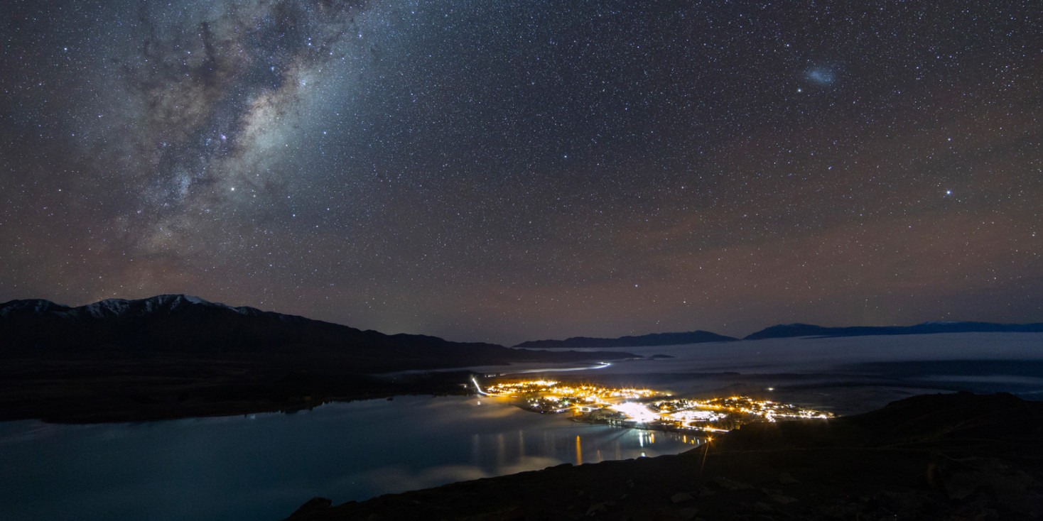 View of Takapo from Mount John with milky way in sky 