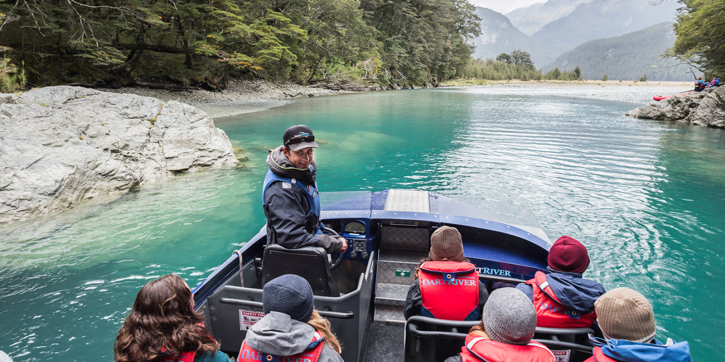 Jet Boat Driver talking to passengers on boat with beautiful river in the background
