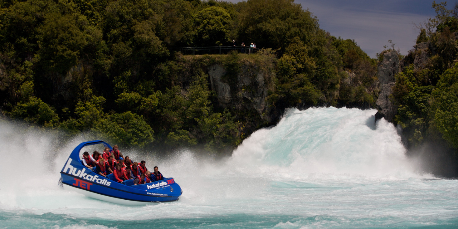 Jet boat doing a spin amongst the white water of powerful waterfall